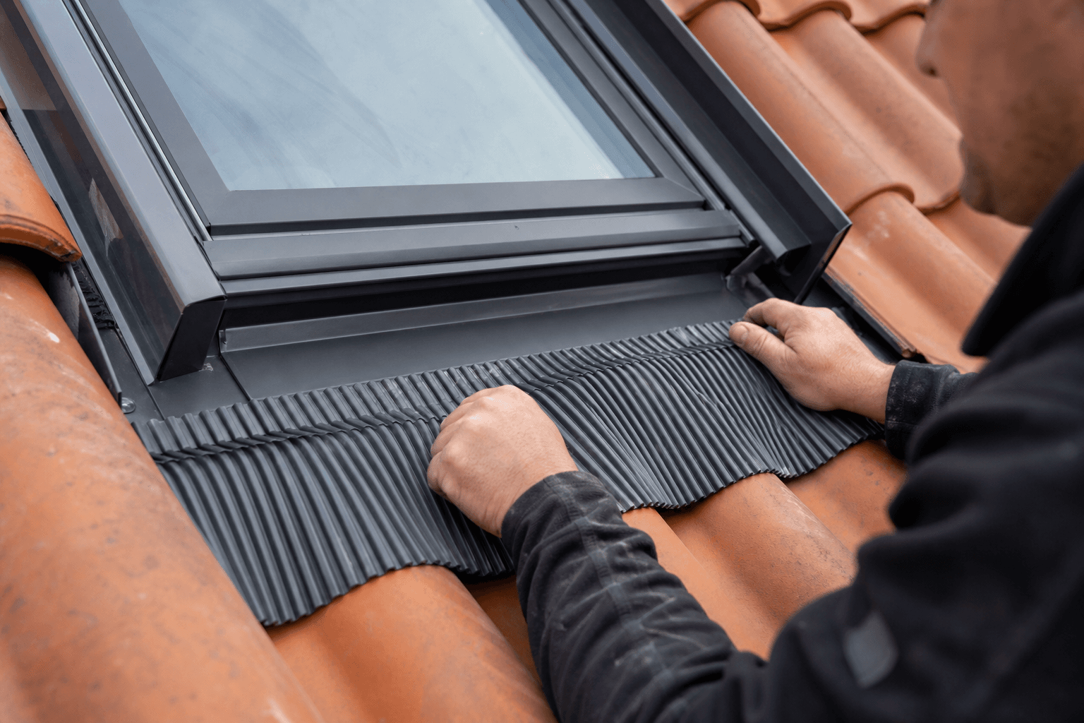 Raccord d'étanchéité autour d'une fenêtre de toit sur couverture en tuiles